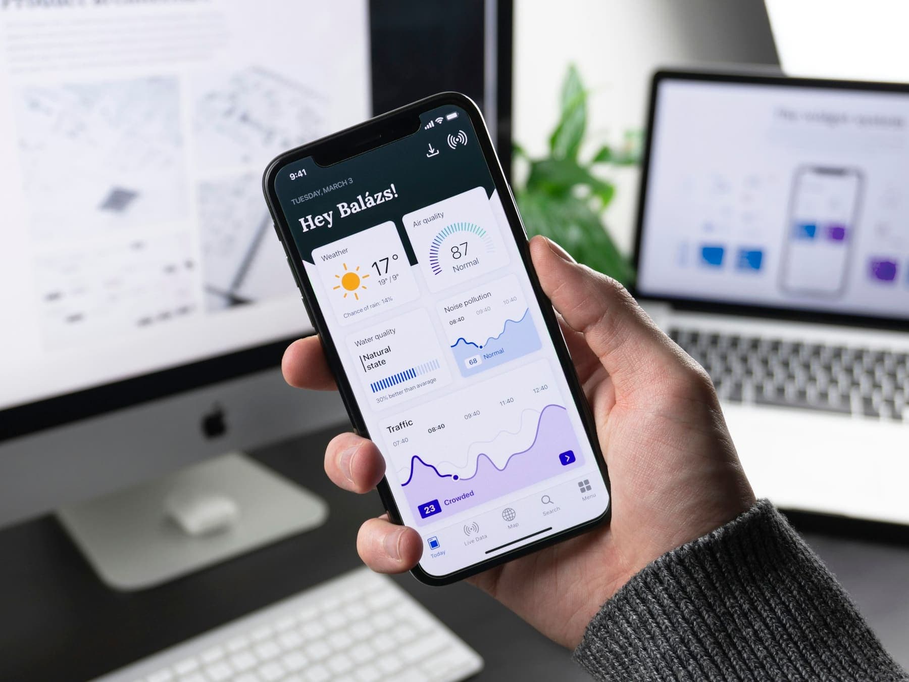 Hand holding a phone showing an analytics app