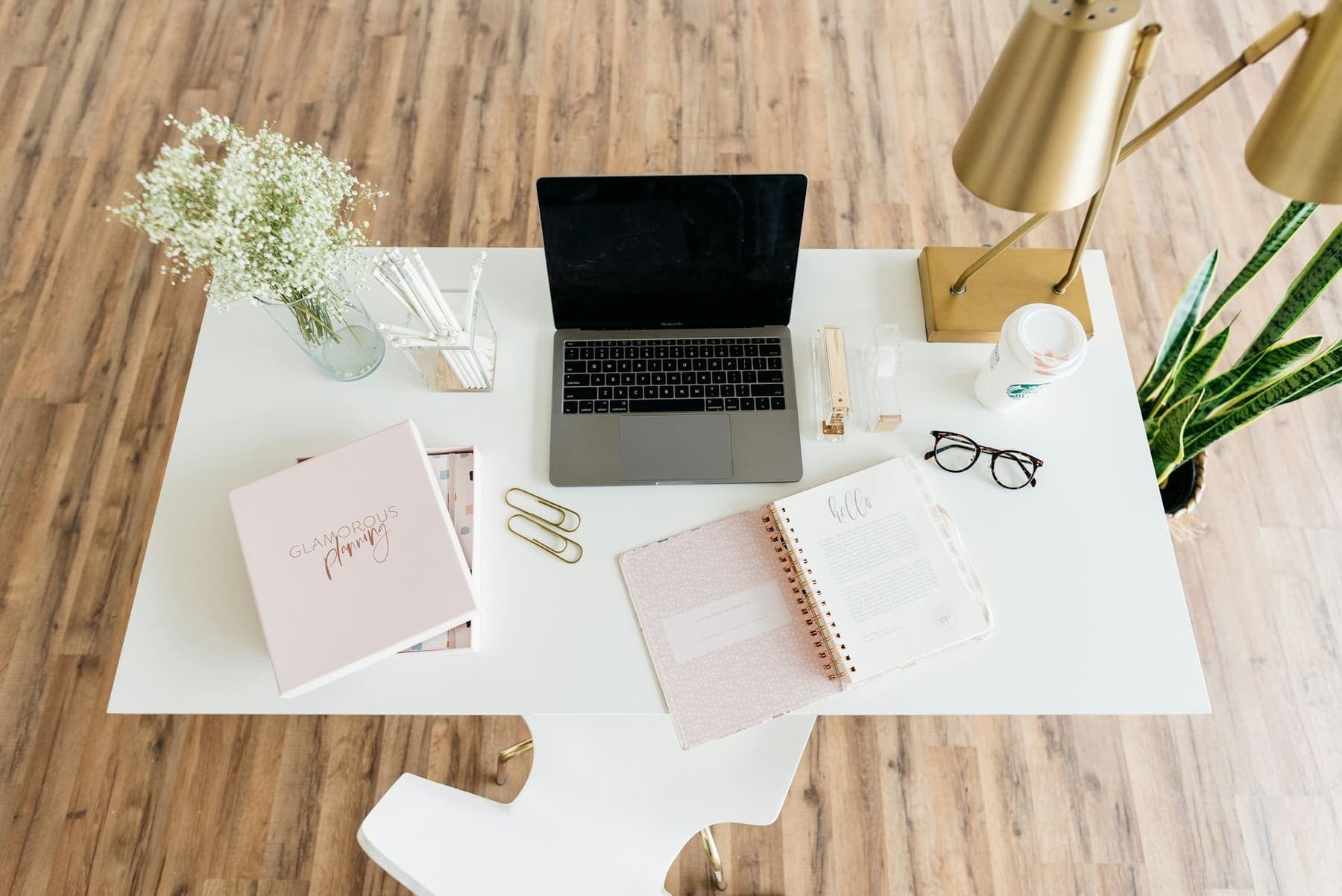 Tidy desk with a laptop, notebook and plant